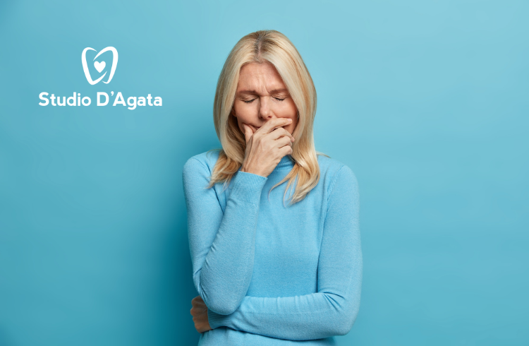 Una donna si tiene la mandibola a causa di un forte dolore ai denti