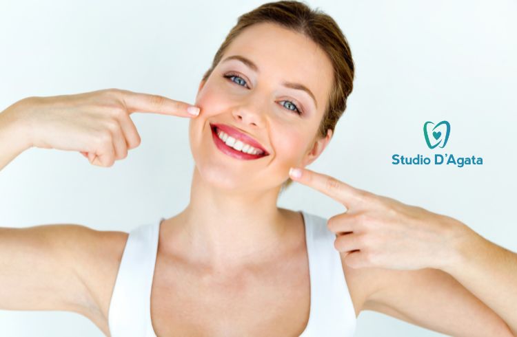 Una donna mostra un sorriso smagliante mentre lo indica con entrambe le mani