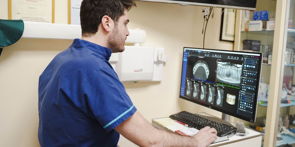 Un dentista dello Studio Dentistico D'Agata analizza radiografie dentali al computer