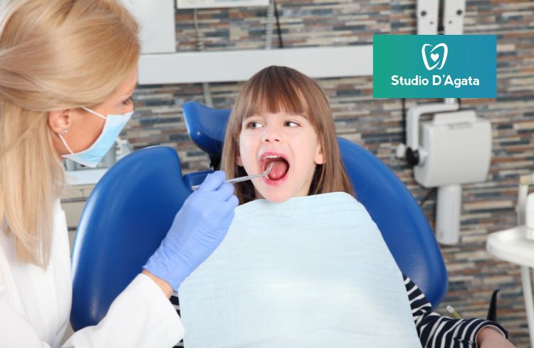 Una bambina con la bocca aperta riceve una visita odontoiatrica allo Studio Dentistico D'Agata